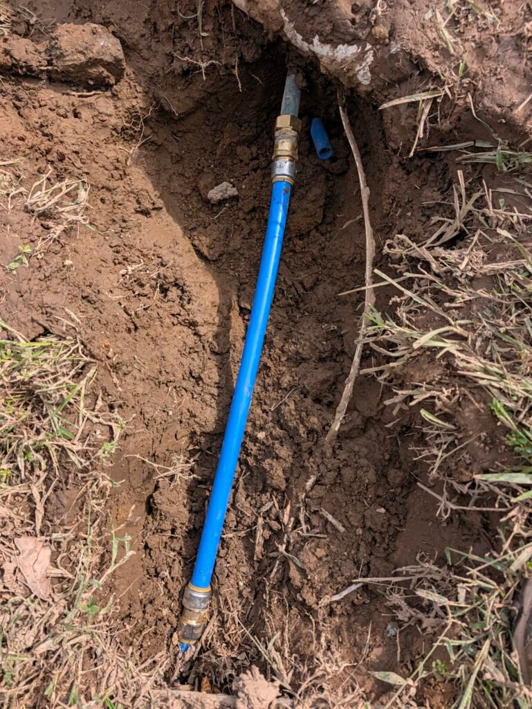 Completed underground copper water line repair with PEX bridge and brass compression fittings