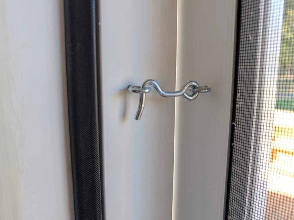 Zinc hook and eye latch installed on the inside jamb of a vinyl screen door