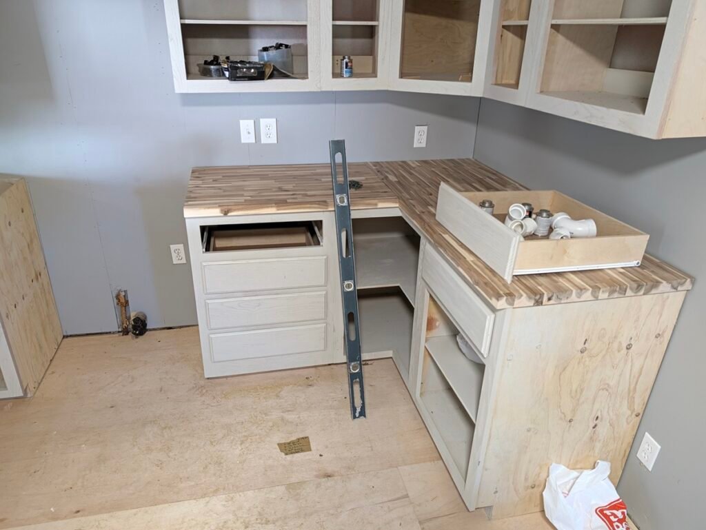 Using a 2-foot level to check butcher block countertops on a corner cabinet