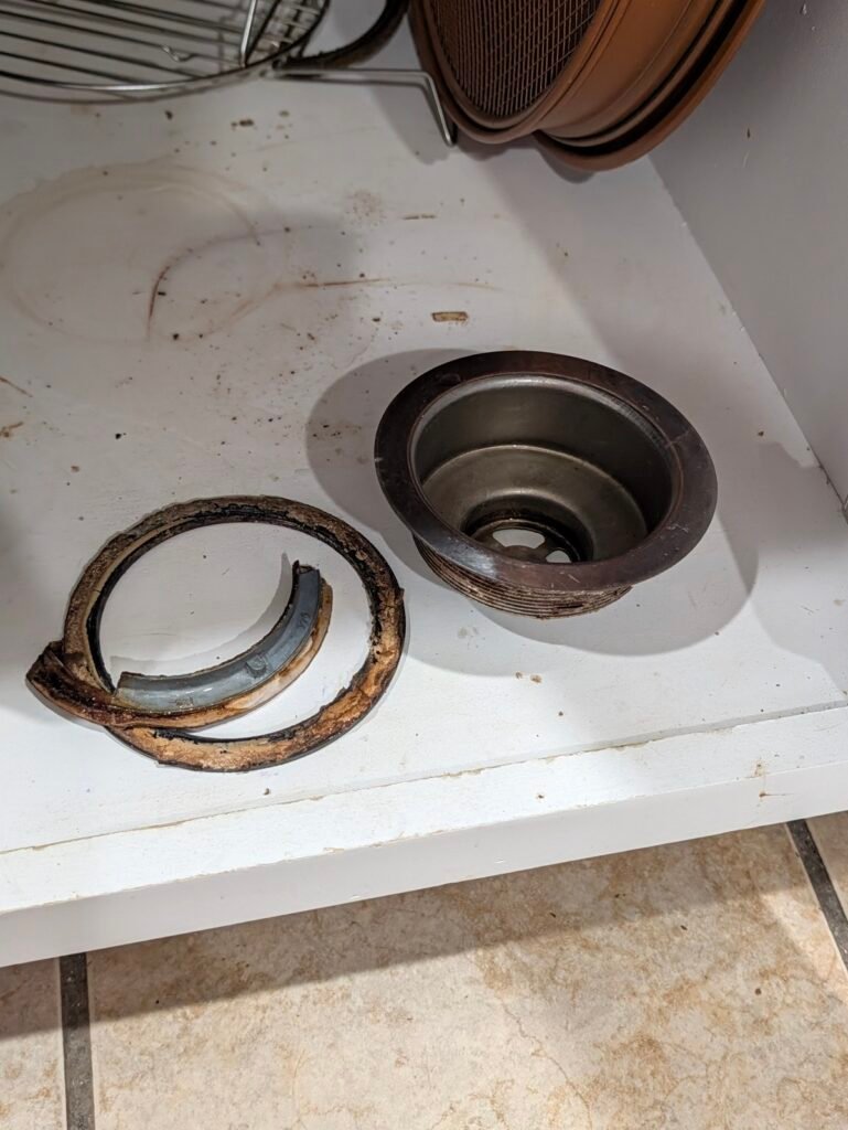 Broken plastic locknut removed when learning how to replace a kitchen sink basket strainer