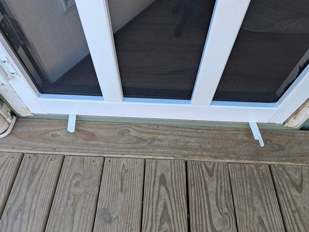 Using trimmed vinyl off-cuts as spacers under the screen door threshold